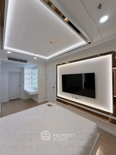 Luxurious bedroom with modern lighting and wall-mounted TV