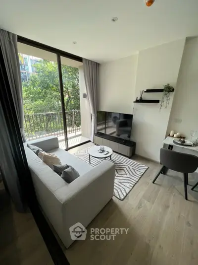 Modern living room with large windows and balcony view, stylish decor and cozy seating area.