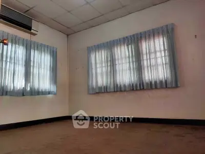 Spacious empty room with large windows and air conditioning, perfect for customization.