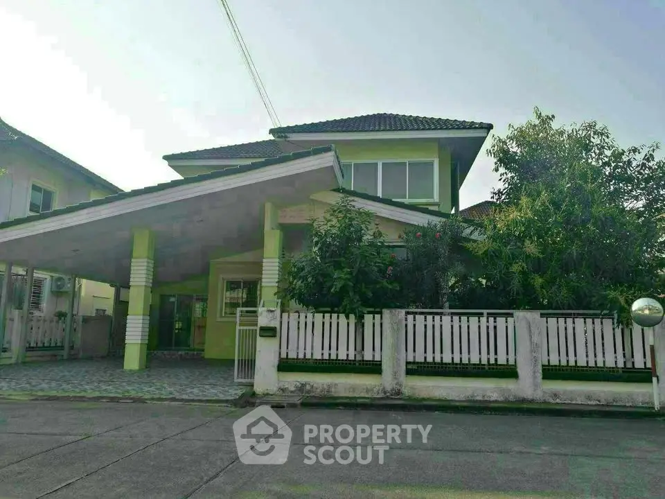 Charming two-story house with lush garden and spacious driveway in a serene neighborhood.