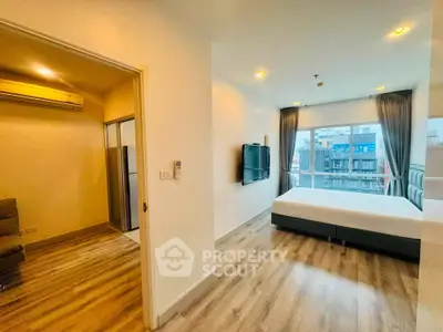 Modern bedroom with large window and city view, featuring stylish flooring and wall-mounted TV.