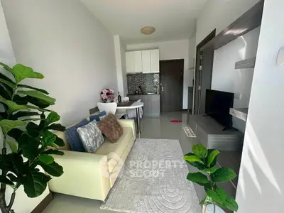 Modern living room with cozy sofa, stylish decor, and open kitchen layout in a bright apartment.