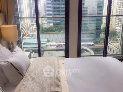 Luxurious bedroom with stunning city view from floor-to-ceiling windows in high-rise apartment.