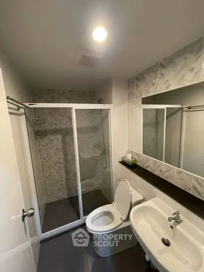 Modern bathroom with glass shower enclosure and sleek fixtures