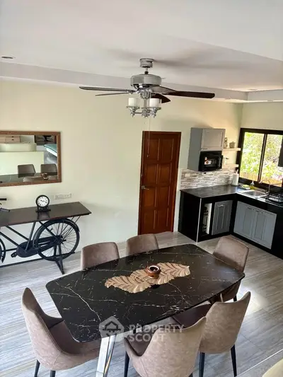 Modern dining area with stylish table, chairs, and open kitchen layout in a contemporary home.
