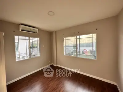 Spacious unfurnished room with hardwood floors and large windows