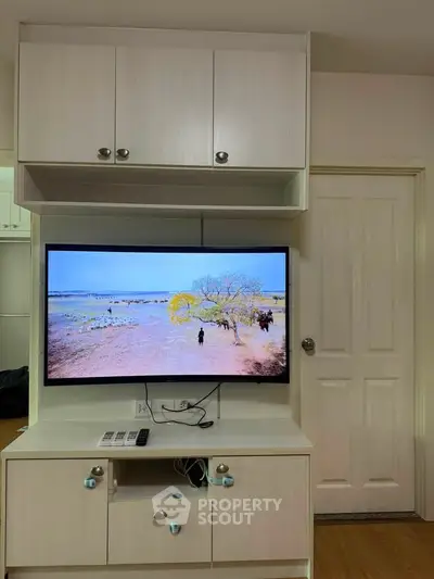 Modern living room with built-in TV cabinet and sleek storage solutions.