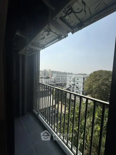 Modern balcony with city view and greenery, perfect for relaxation and enjoying urban living.
