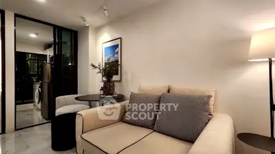 Cozy living room with modern decor and open kitchen view.