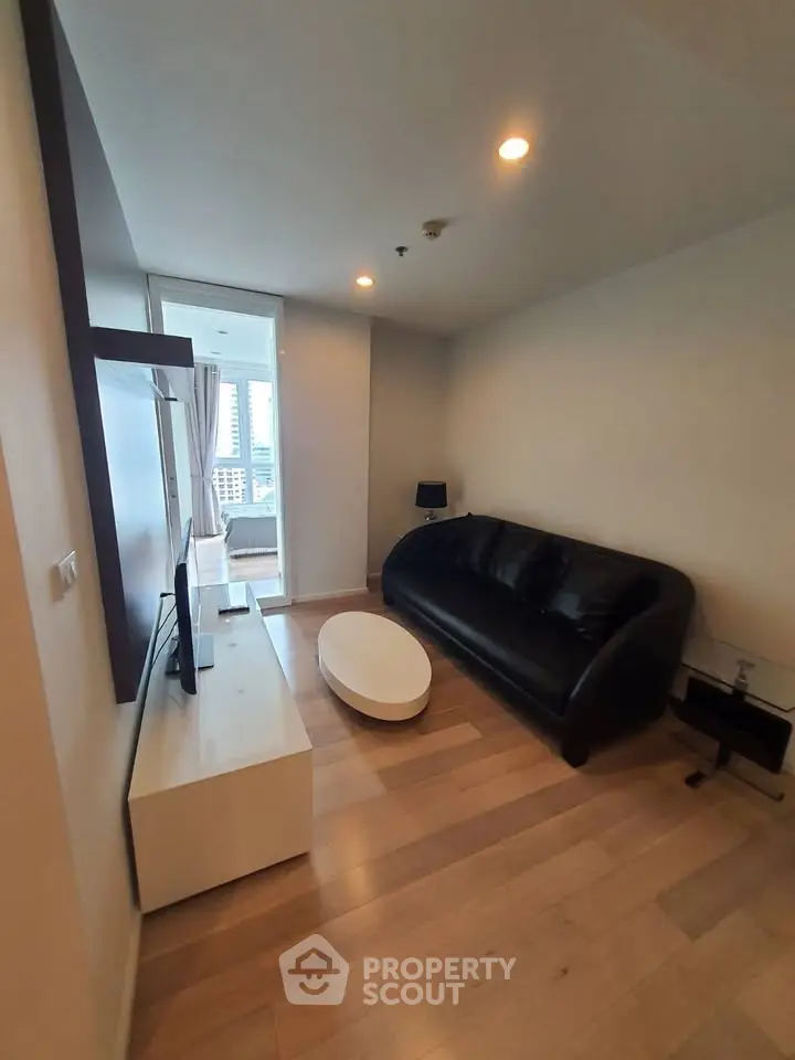 Modern living room with sleek black sofa and city view