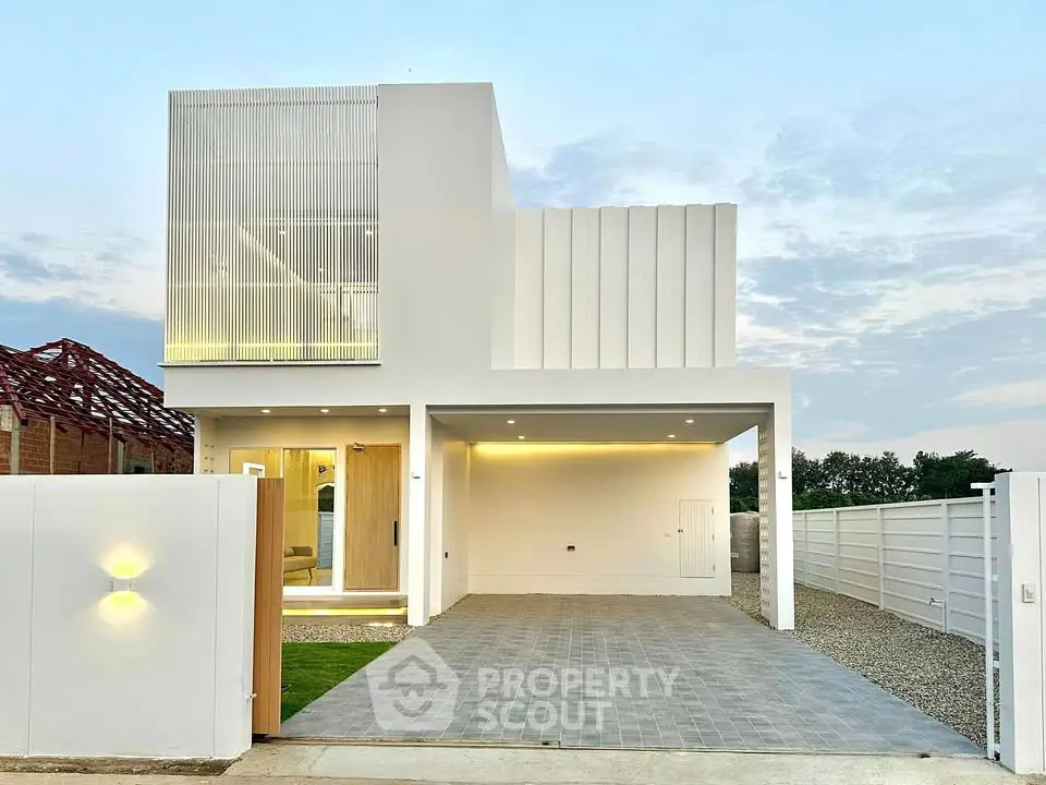 Modern minimalist white house with spacious driveway and sleek architectural design.