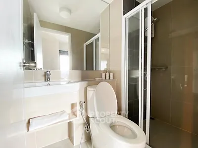 Modern bathroom with sleek design, featuring a glass shower and contemporary fixtures.
