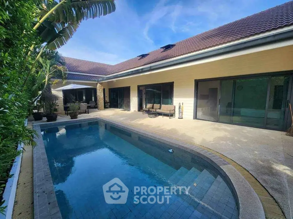 Luxurious villa with private pool and spacious patio under clear blue skies.