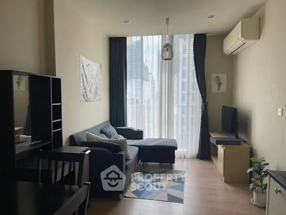 Modern living room with sleek furniture and large window offering city view.