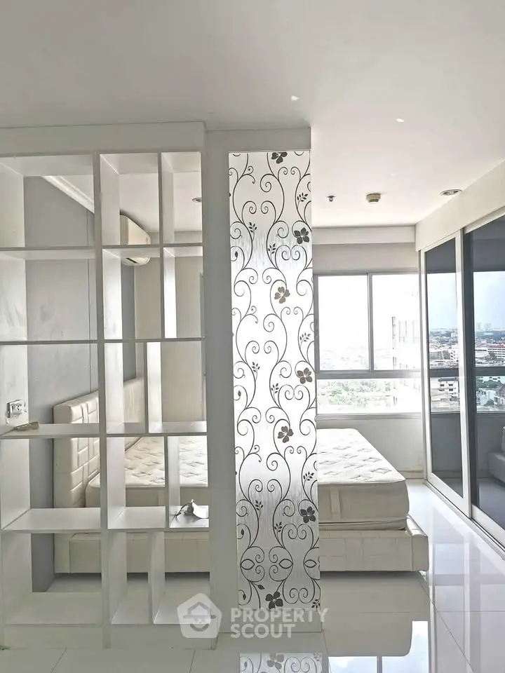 Modern bedroom with decorative partition and city view, featuring sleek design and natural light.