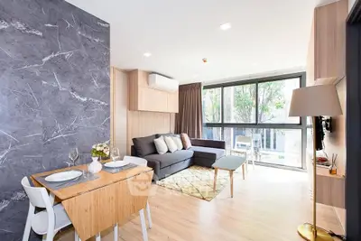 Modern living room with large windows, stylish furniture, and elegant decor in a bright apartment.