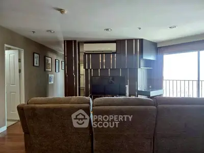 Spacious living room with modern decor and large windows offering natural light.