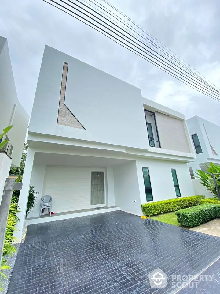 Modern minimalist white house exterior with sleek design and lush green landscaping