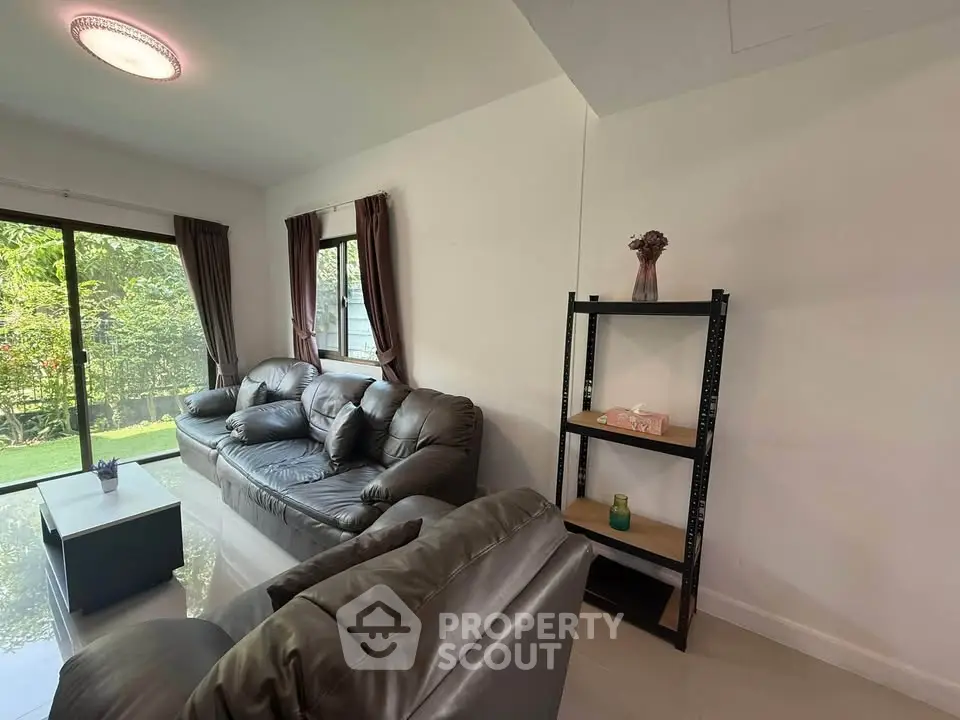 Spacious living room with leather sofas and garden view
