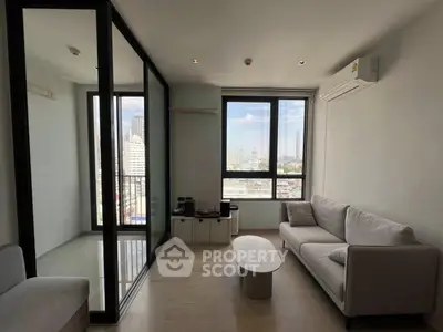 Modern living room with city view, featuring sleek furniture and large windows for natural light.