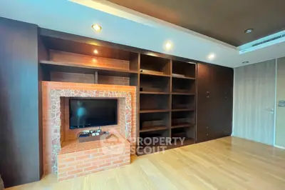 Spacious living room with built-in shelves and brick TV feature wall