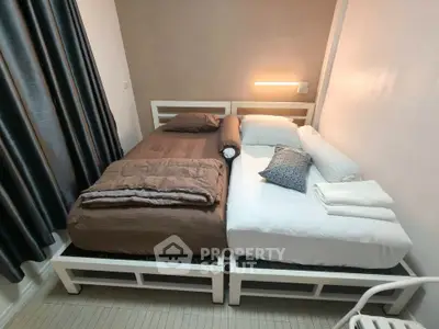 Cozy bedroom with twin beds and modern lighting in a stylish apartment.