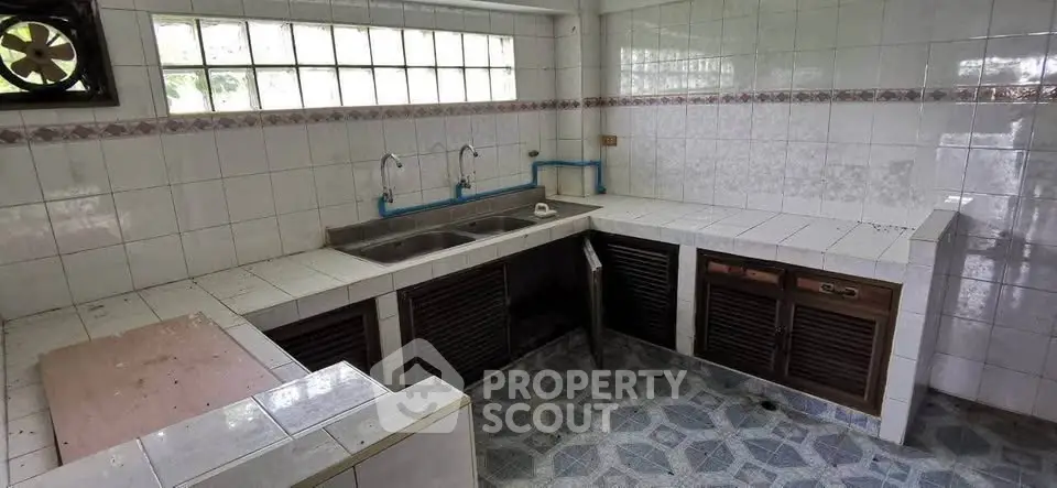 Spacious kitchen with dual sinks and tiled countertops, ideal for renovation.