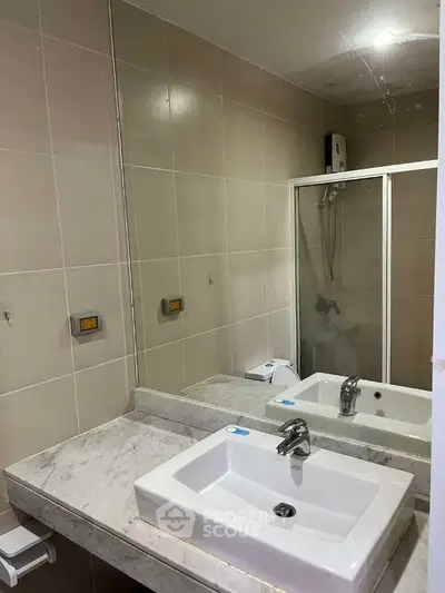 Modern bathroom with sleek sink and glass shower enclosure