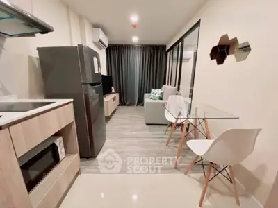 Modern open-layout living room with sleek kitchen and stylish decor in a cozy apartment.