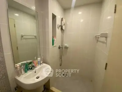 Compact bathroom with modern fixtures and a sleek shower area, perfect for urban living.