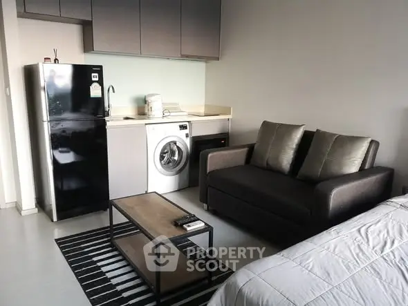 Modern studio apartment with compact kitchen and cozy living area.