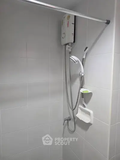 Modern bathroom with sleek shower and water heater in minimalist design.