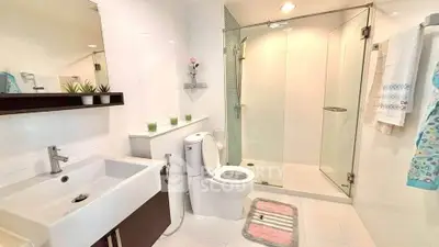 Modern bathroom with glass shower, sleek sink, and stylish decor in a contemporary home.
