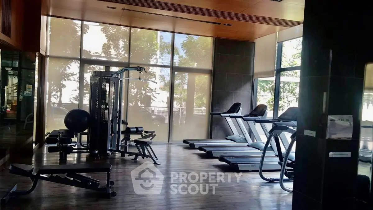 Modern gym with state-of-the-art equipment and large windows for natural light.