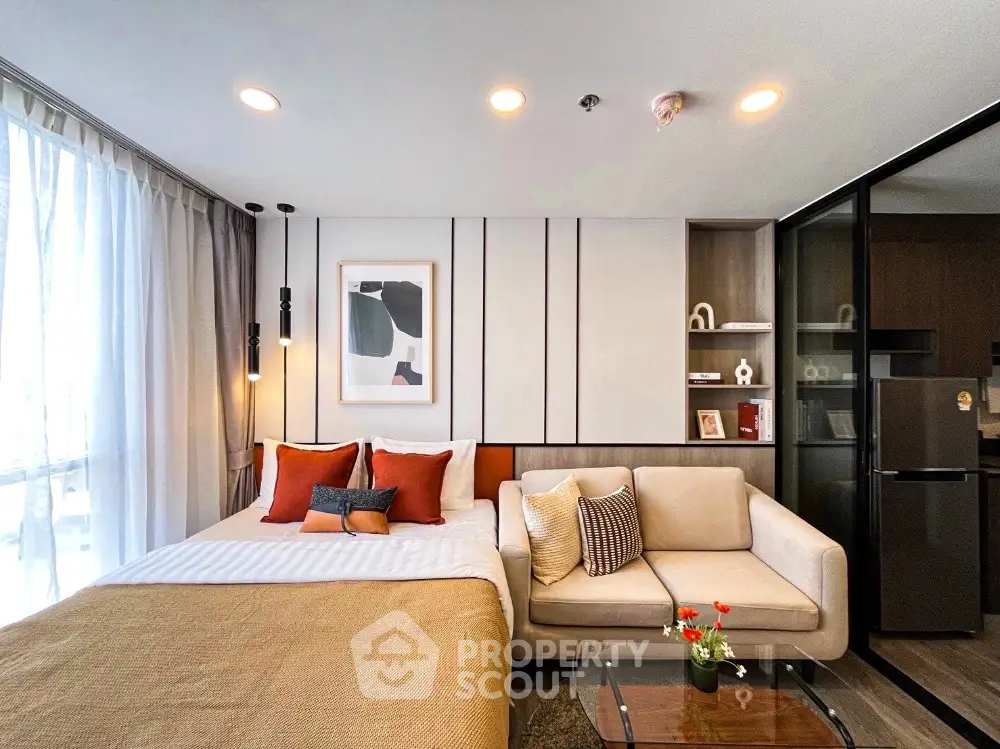 Modern studio apartment with cozy bed, stylish sofa, and contemporary decor