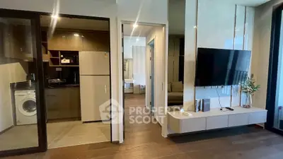 Modern apartment interior with open kitchen, living area, and washing machine.