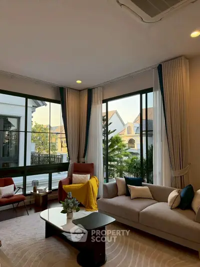 Elegant living room with large windows and stylish decor in a modern home.