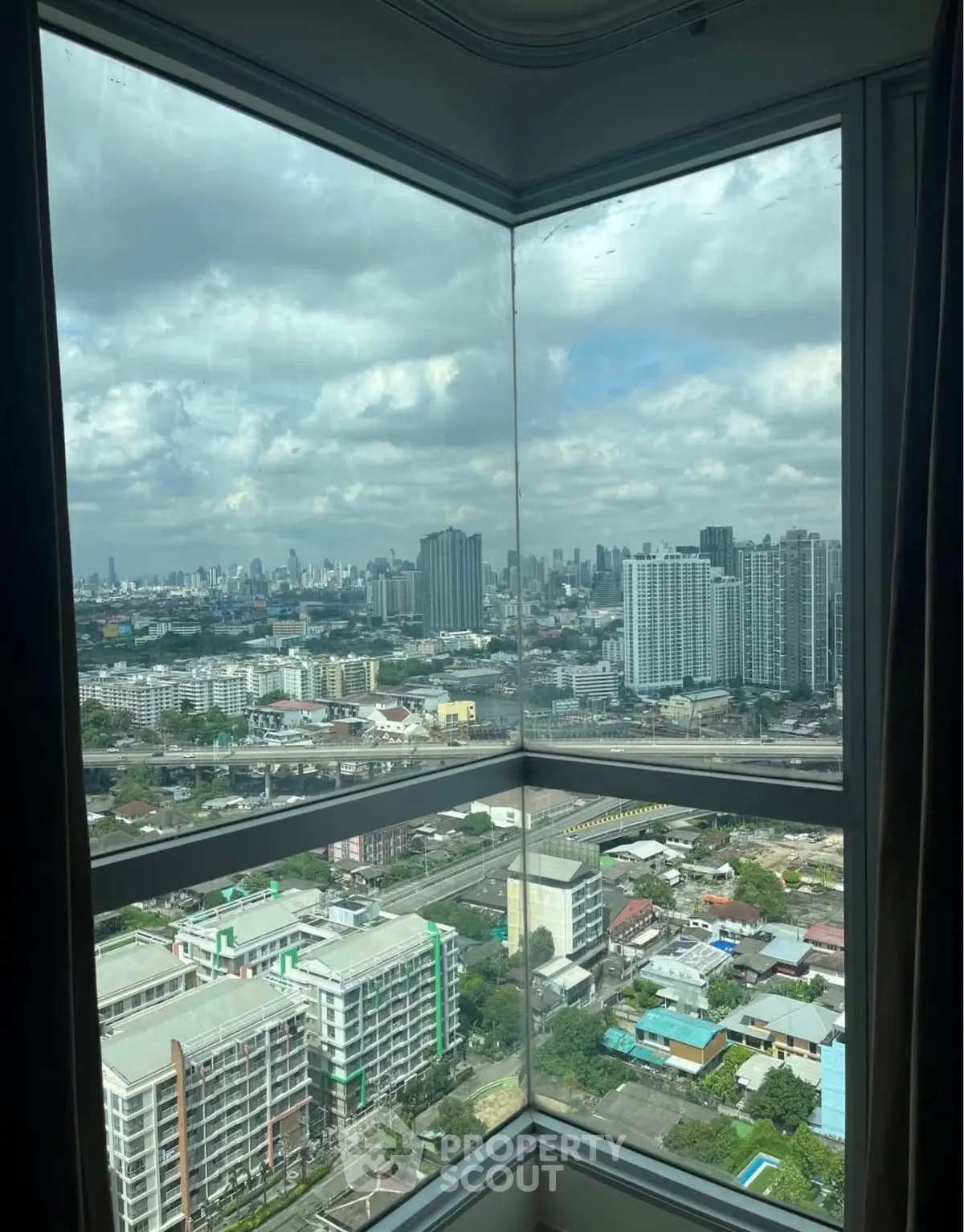 Stunning cityscape view from high-rise apartment window with expansive skyline.