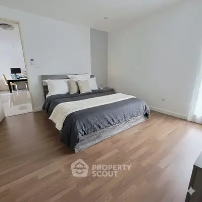 Spacious modern bedroom with wooden flooring and elegant decor