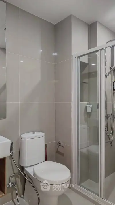 Modern bathroom with sleek shower and toilet in neutral tones