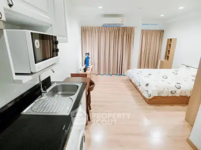 Modern studio apartment with integrated kitchen and cozy bedroom area