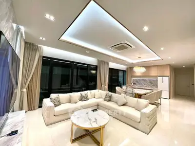 Luxurious open-plan living room with elegant decor and modern kitchen in a spacious apartment.