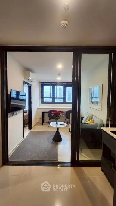Modern living room with glass partition, cozy seating, and city view, perfect for urban living.