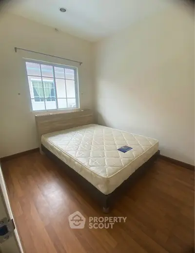 Cozy bedroom with natural light and wooden flooring