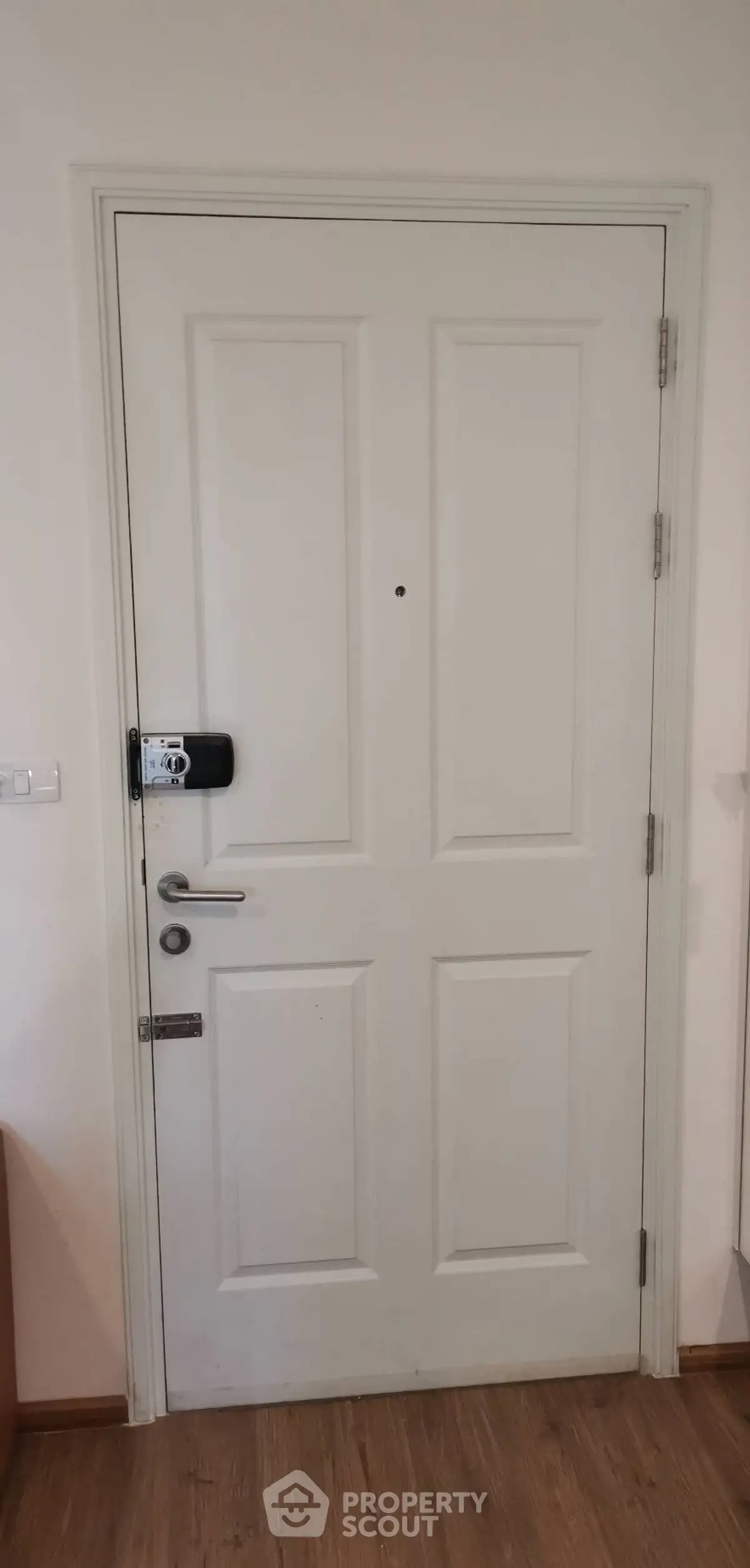 Sturdy white interior door with modern lock in a residential setting.