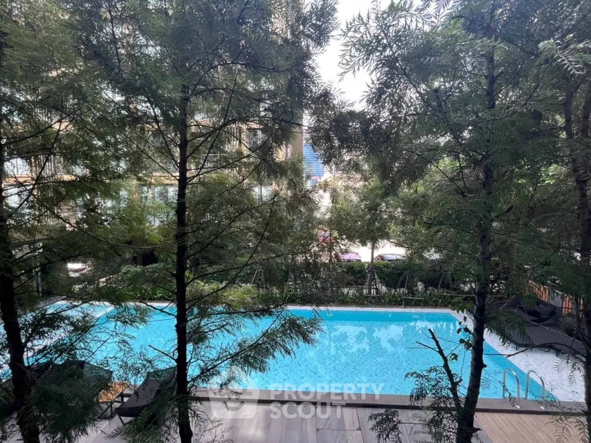 Luxurious residential pool surrounded by lush greenery, offering a serene escape in the heart of the city.