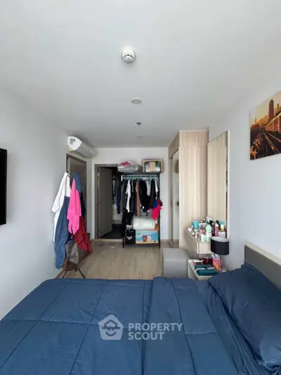 Modern bedroom with open closet and stylish decor in urban apartment.