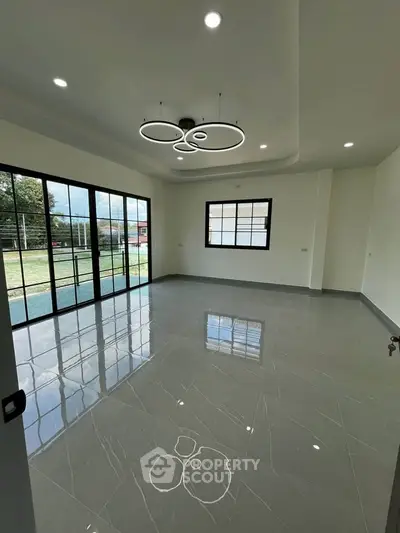 Spacious modern living room with large windows and stylish lighting