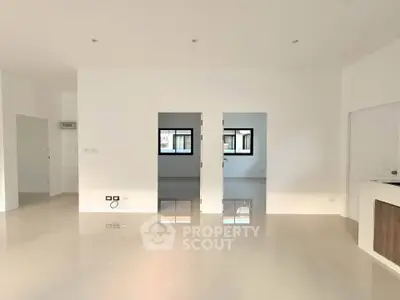 Spacious modern living room with glossy tile flooring and ample natural light.