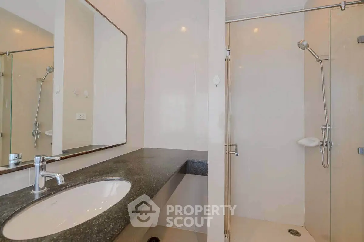 Modern bathroom with sleek design featuring a glass shower and elegant countertop.